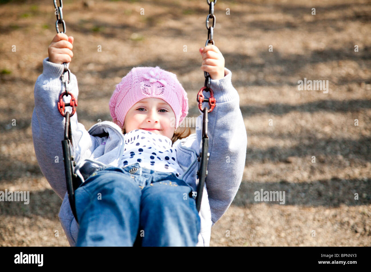 Petite fille se balançant sur une journée de printemps dans le parc. Banque D'Images