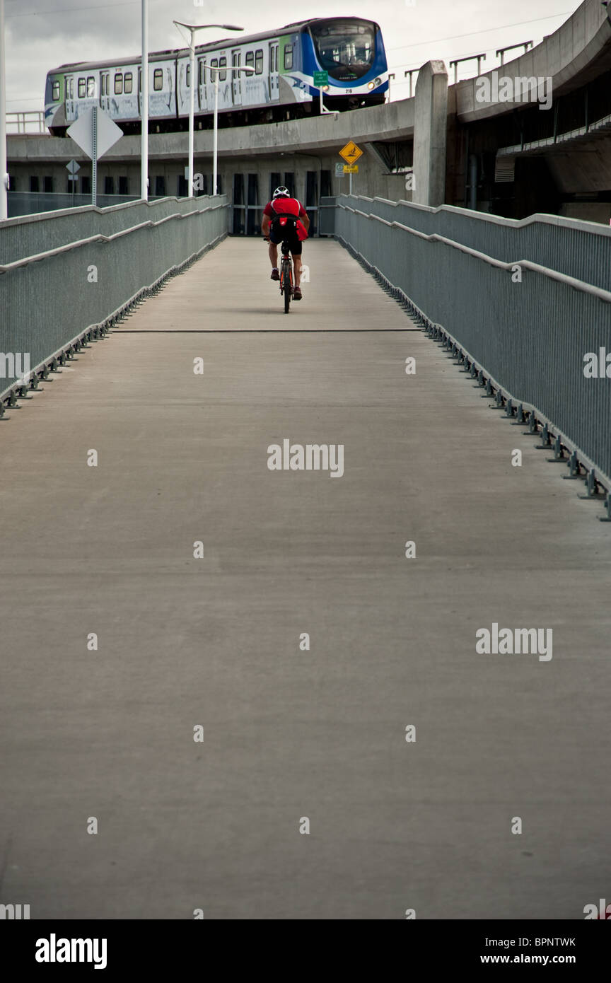Un cycliste à cheval sur un pont sur le métro de la rivière Fraser à Vancouver, BC Banque D'Images