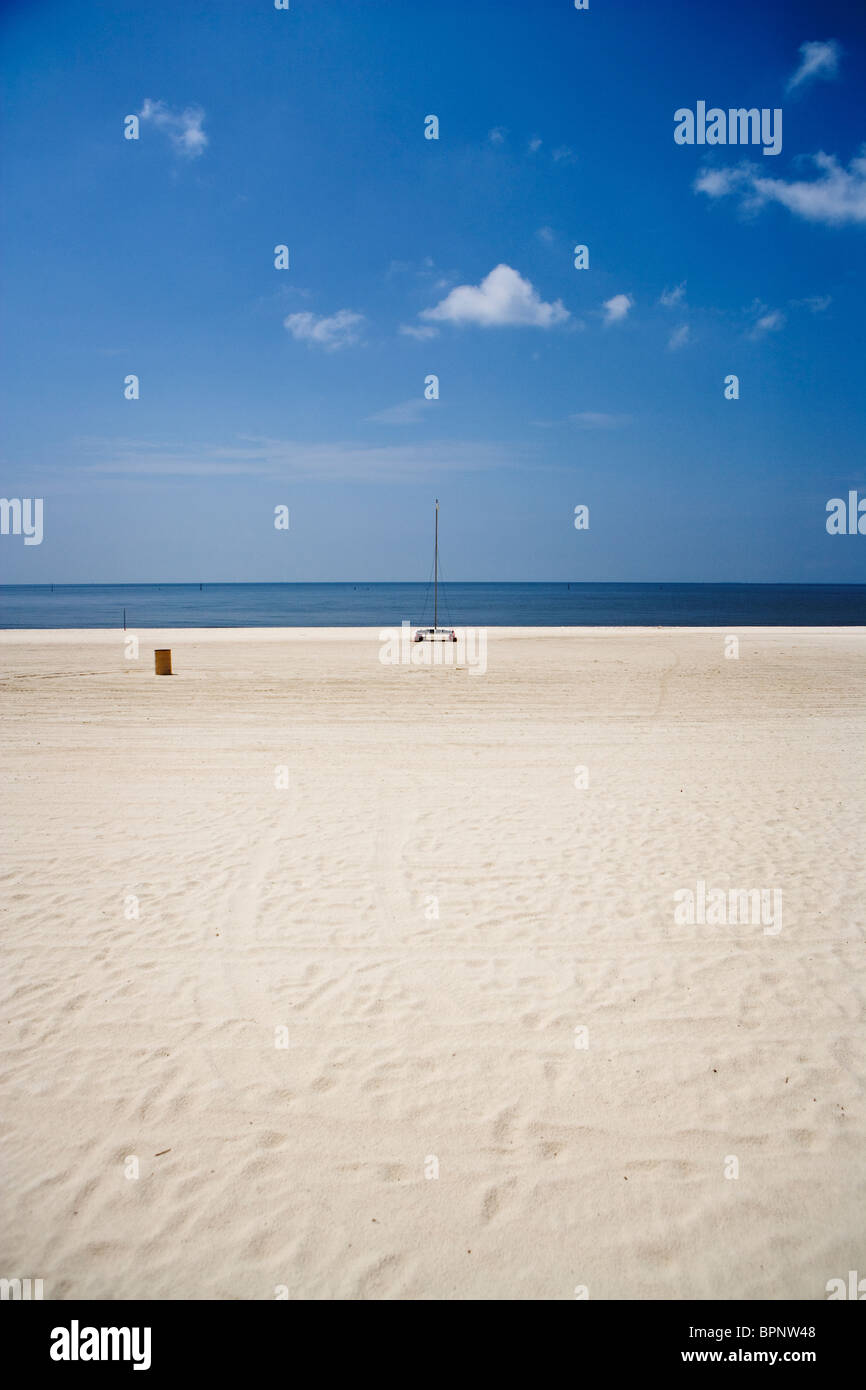 Une plage propre et vide le long de la côte du golfe du Mexique en juillet avec seulement un petit catamaran unique. Banque D'Images