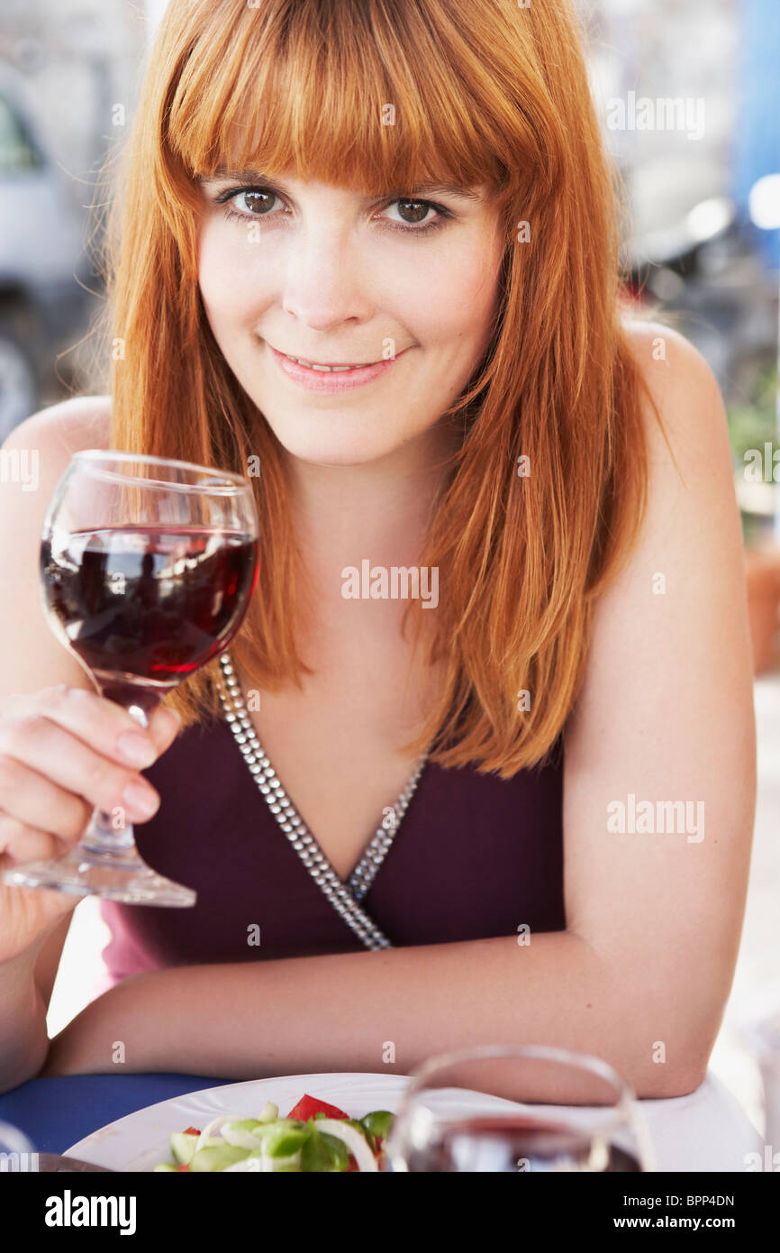 Jeune femme en sirotant du vin rouge Banque D'Images