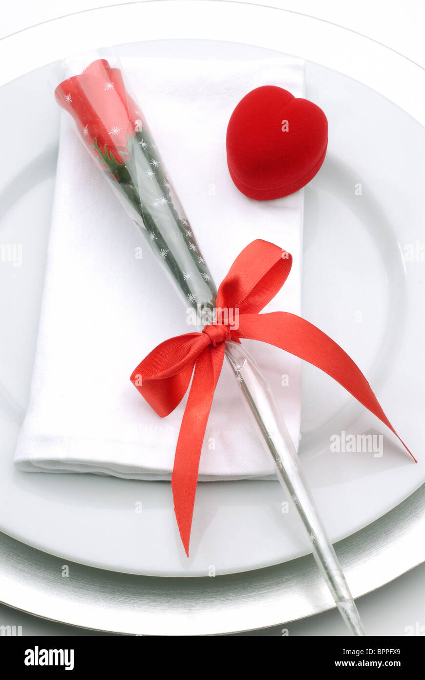 Assiette à dîner avec un cadeau de Saint-Valentin une rose rouge et anneau en forme de coeur fort Banque D'Images