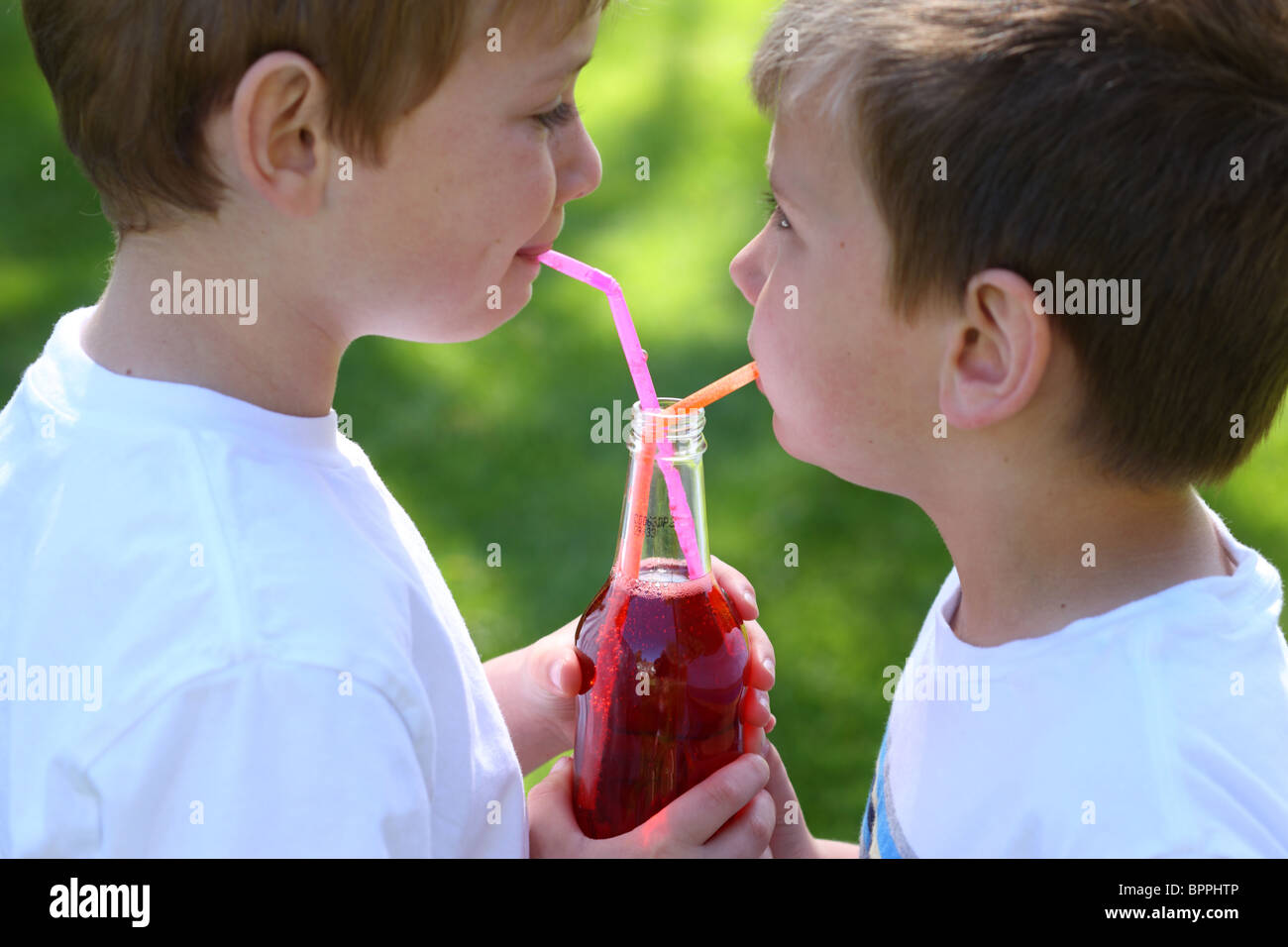 Deux jeunes garçons partageant une bouteille de soda Banque D'Images