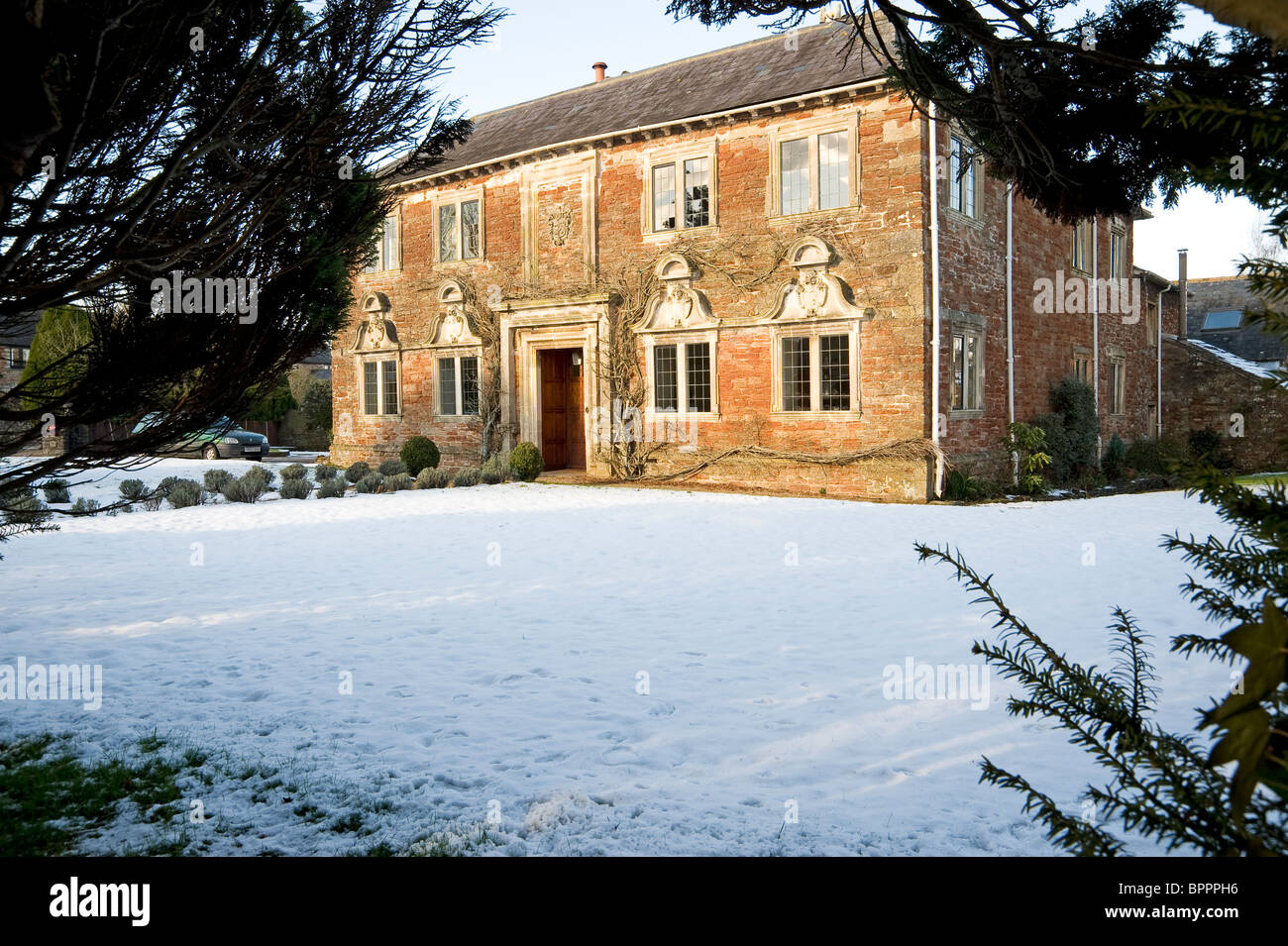 Maison traditionnel anglais dans la neige, avec porte en fer ornemental : Manoir de Tilly, West Harptree Banque D'Images