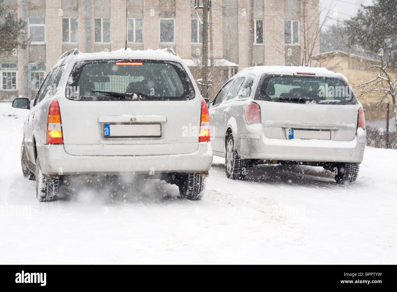 Deux d'argent voiture européenne sur route enneigée. Banque D'Images