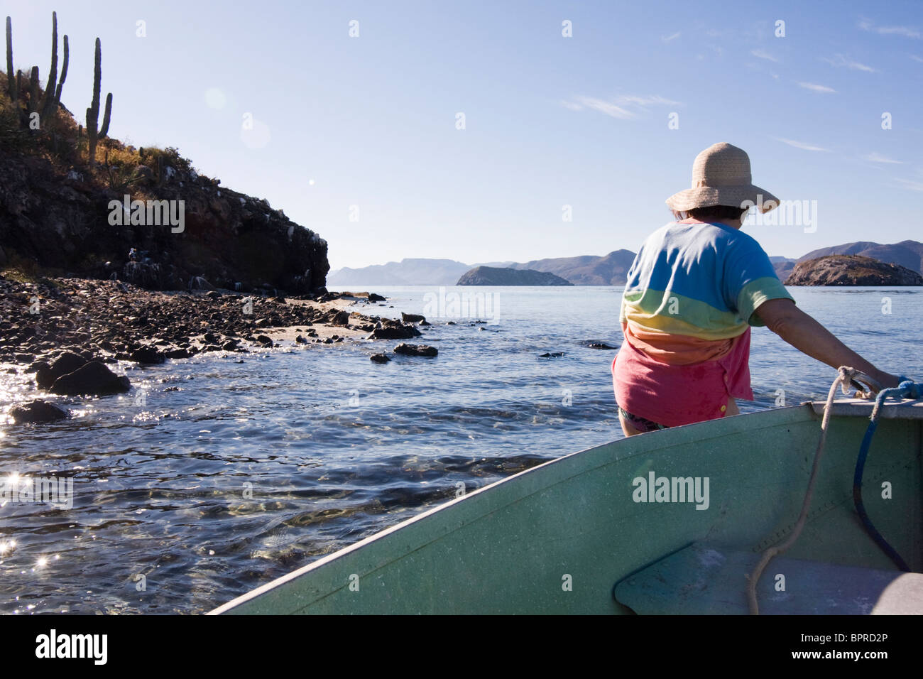 Une femme mature tire une barque sur la rive dans la Bahia de Concepcion, Baja California, au Mexique. Banque D'Images