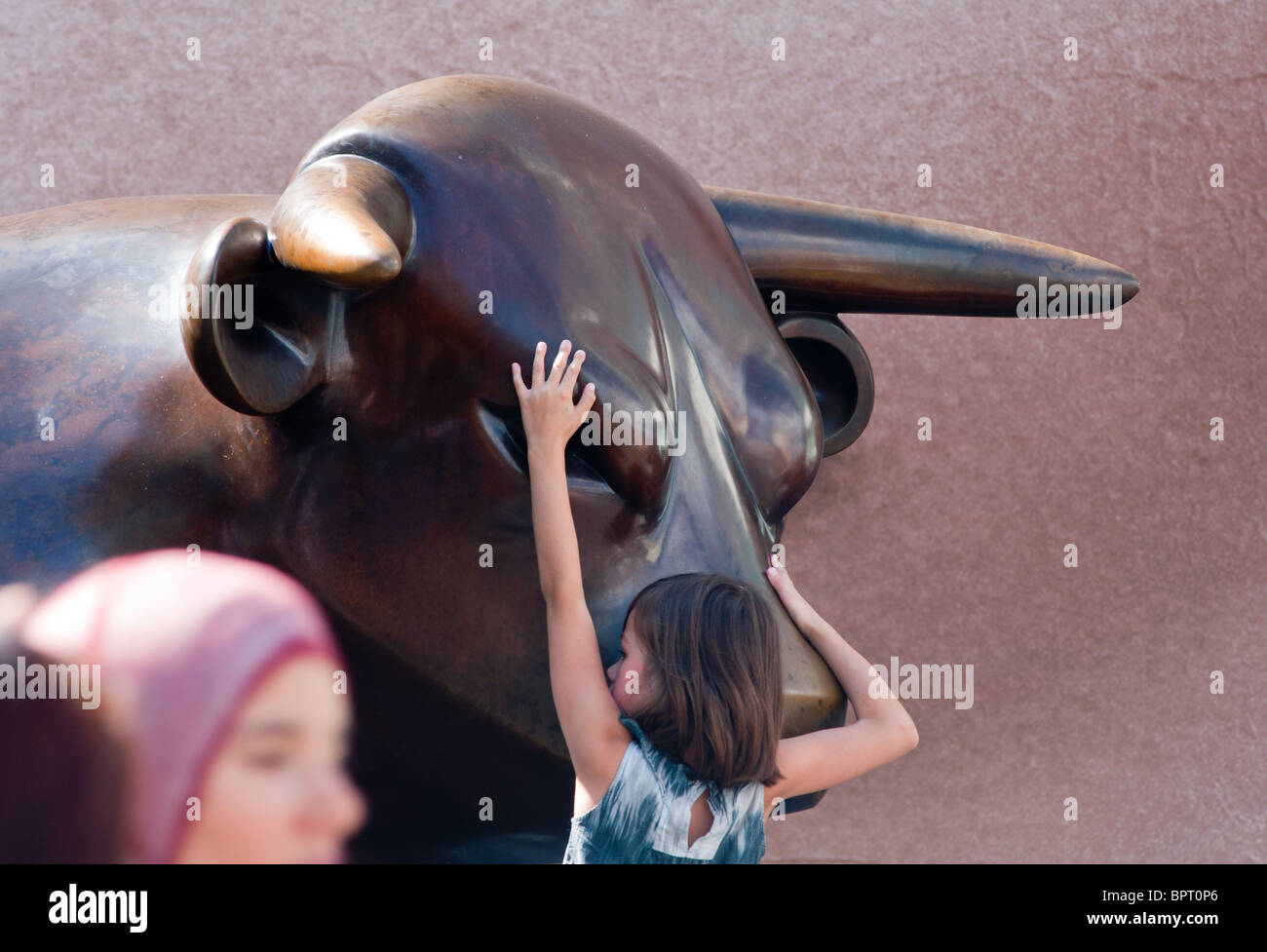 Petite fille à l'extérieur de la sculpture avec Bull centre commercial Bullring à Birmingham. Banque D'Images