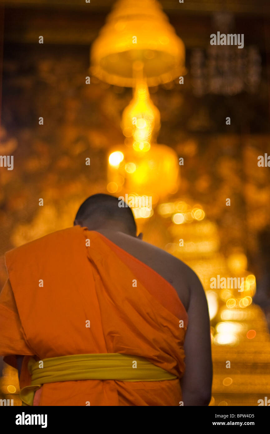 Un moine s'agenouille devant une statue de Bouddha de Wat Po, Grand Palace, Bangkok, Thaïlande. L'Indochine. En Asie du sud-est. Janvier 2010 Banque D'Images