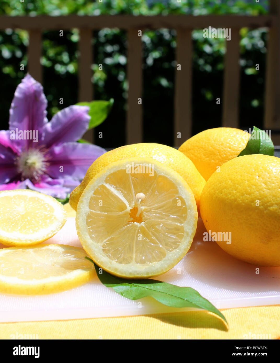 Couper et citrons entiers sur un tableau blanc à l'extérieur, d'une clôture à l'arrière-plan Banque D'Images