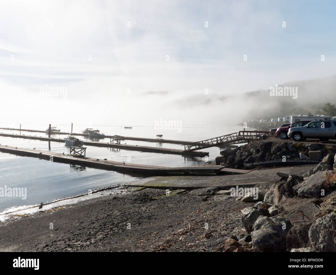 Grâce à la combustion de soleil matin brume sur Clallam Bay & jetées flottantes avec bateaux amarrés au port de port de pêche célèbre Sekiu Banque D'Images