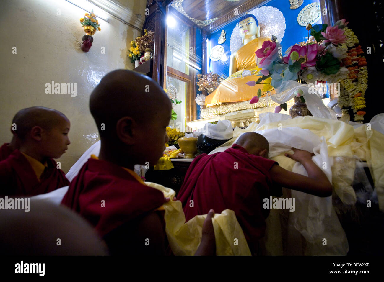 Moines tibétains la visite du Temple de la Mahabodhi en faisant des offrandes au bouddha, Bodhgaya, Bihar, Inde. Banque D'Images