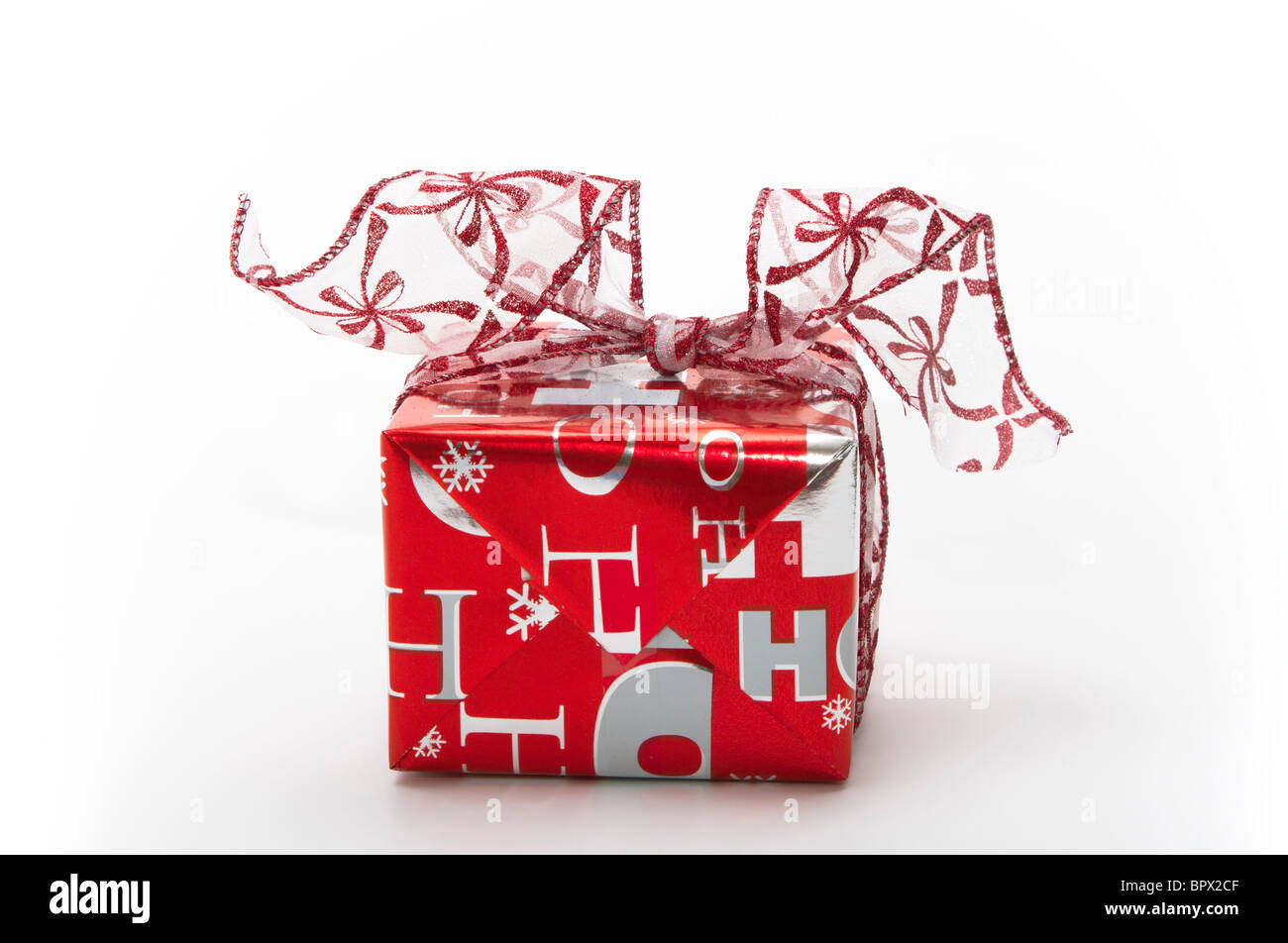 Cadeau de Noël enveloppé dans du papier rouge et argent avec ruban fantaisie Banque D'Images