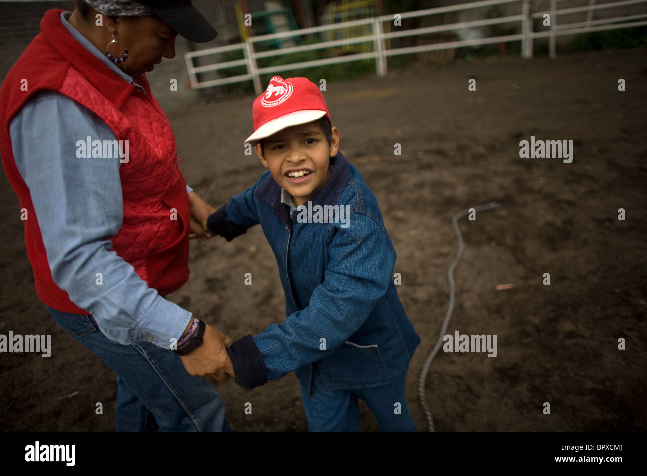 Thérapeute équine Guadalupe guides Pena un garçon autiste à travers un exercice de marche au cours d'une séance de thérapie à cheval dans la ville de Mexico Banque D'Images