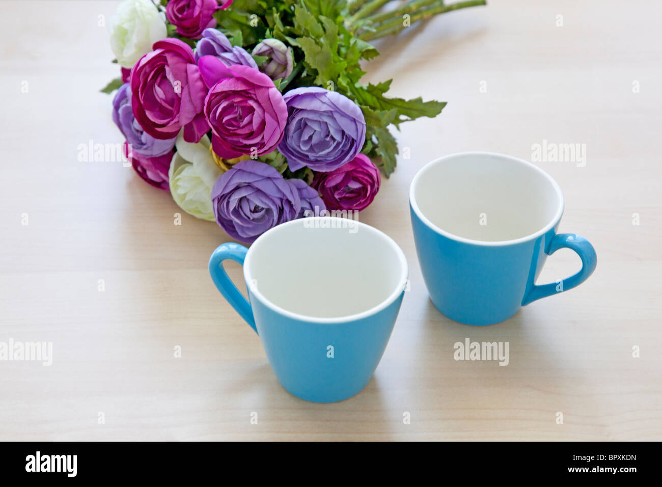 Fleurs et deux tasses de café vide sur la table Banque D'Images