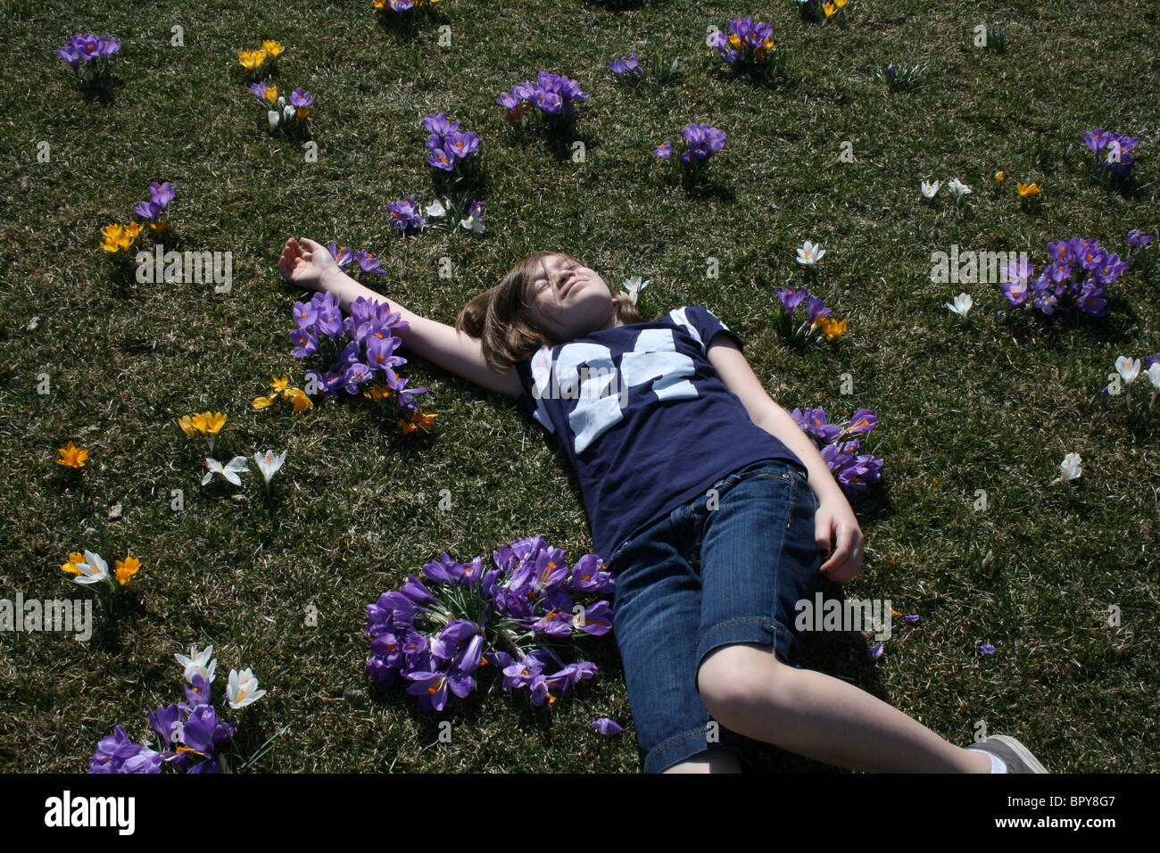 Ahhh les jeunes ! Un ma, une jeune fille, absorbent l avec pas un soin dans le monde au milieu de fleurs dans un pré en fleurs. Banque D'Images