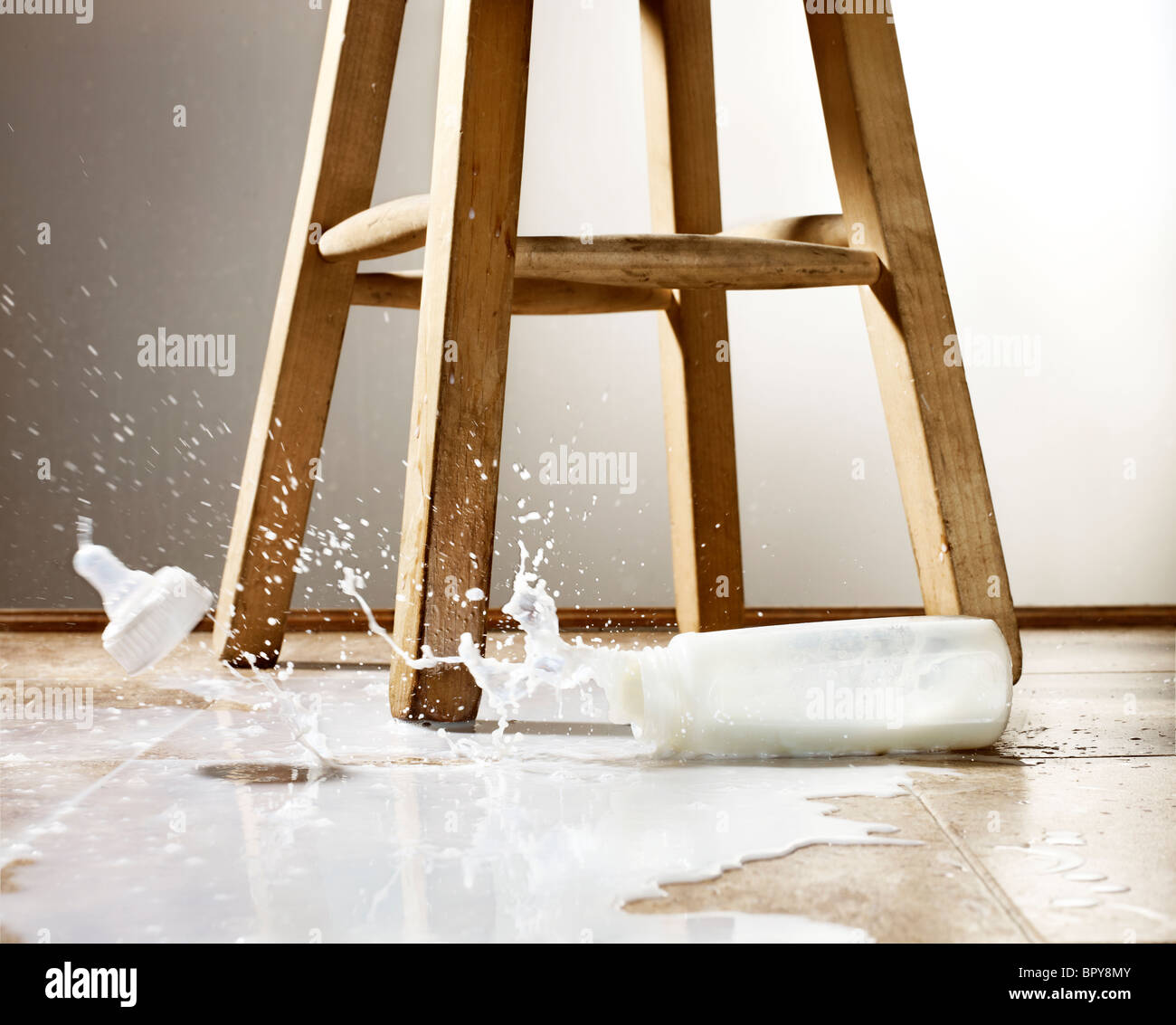 Le biberon et lait renversé avec splash sur un marbre Banque D'Images Le biberon et lait renversé avec splash sur un marbre Banque D'Images