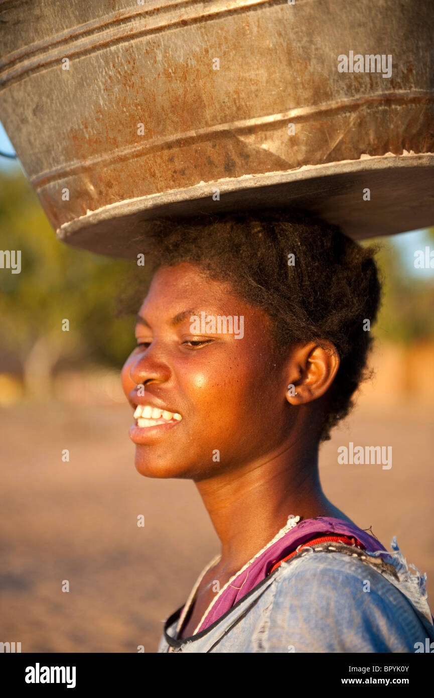 Femme portant un seau sur la tête, Cape Maclear, Malawi Banque D'Images