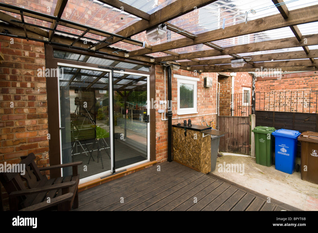 Maison construite en plastique ondulé avec lame de terrasse et de toiture panneaux de dépistage mobile dans un cadre domestique. Manchester, UK. Banque D'Images