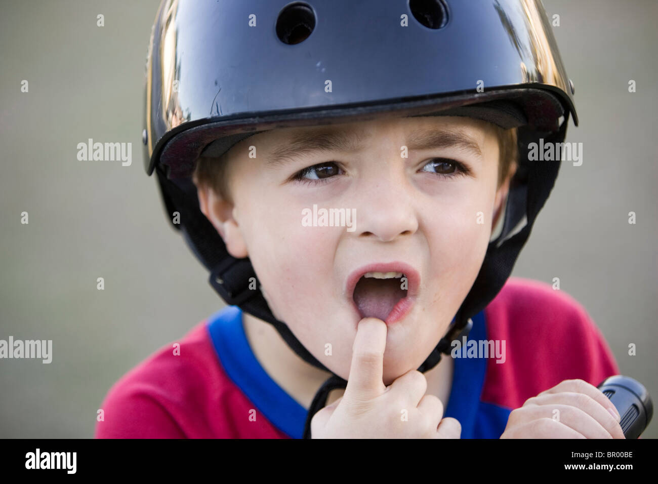 Un jeune garçon dans un casque de vélo rouler à vélo. Banque D'Images