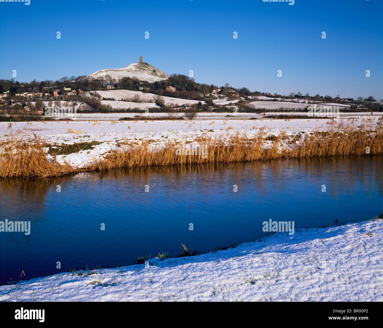 Glastonbury Tor vue sur la rivière Brue sur South Moor dans la neige d'hiver. Glastonbury, Somerset, Angleterre. Banque D'Images