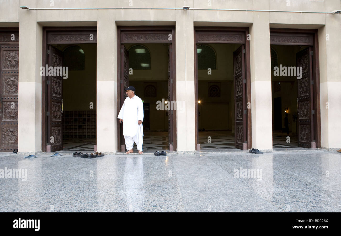 De nombreuses chaussures gauche à l'entrée d'une mosquée à Dubaï et un musulman à autour. Banque D'Images