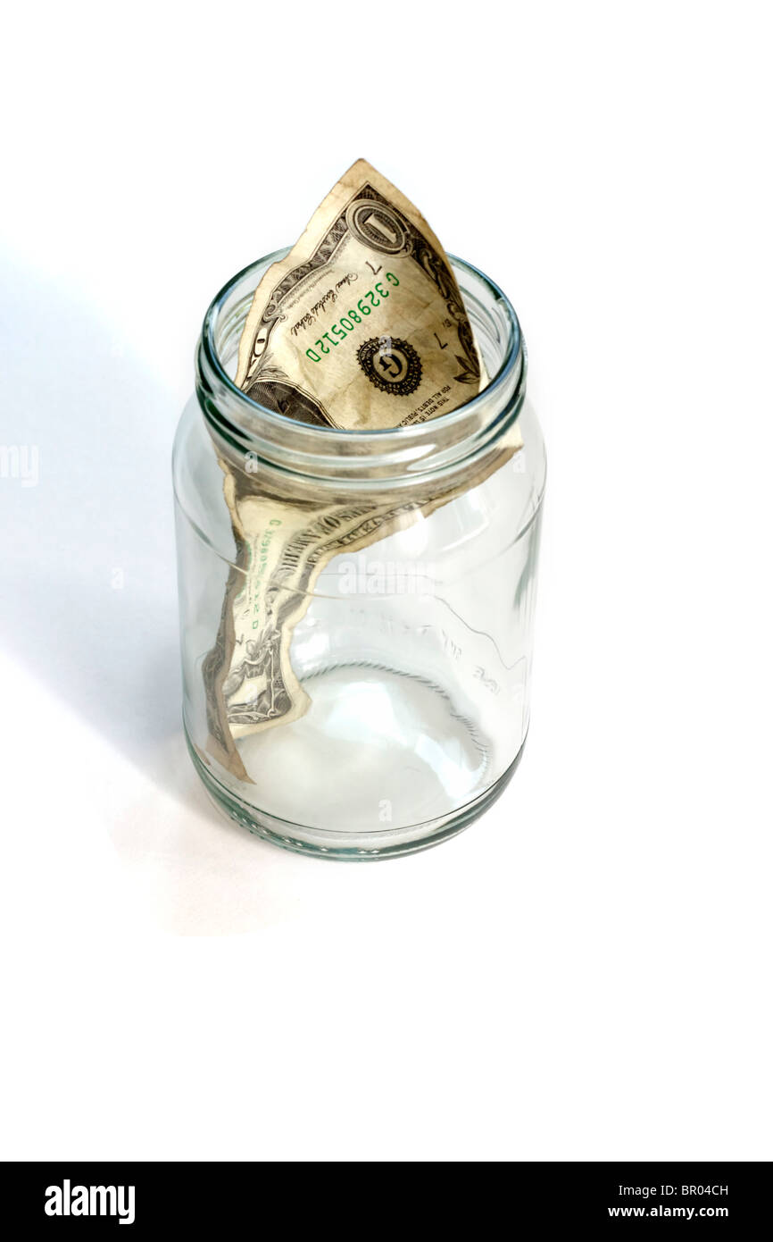 Pot en verre presque vide avec un dollar froissé Banque D'Images
