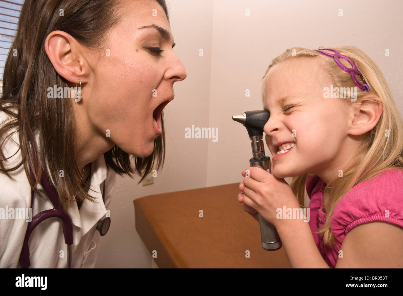 Jeune fille cherche dans la bouche du médecin dans une clinique pédiatrique Banque D'Images
