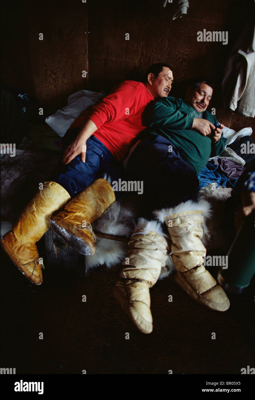 Les chasseurs inuits, passer le temps en attendant une tempête dans une hutte. Banque D'Images