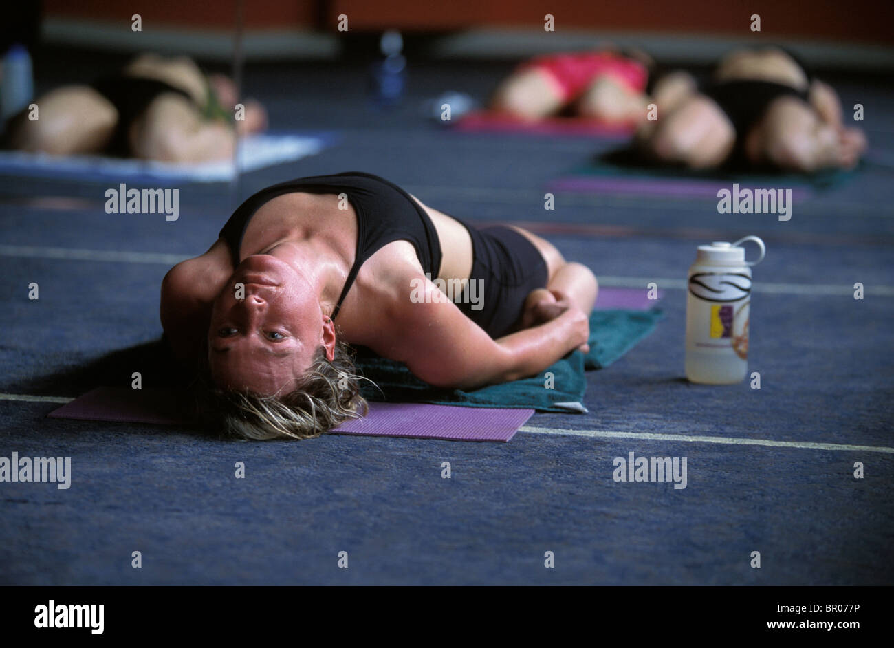 Une athlète féminine s'étendant dans une classe de yoga. Banque D'Images