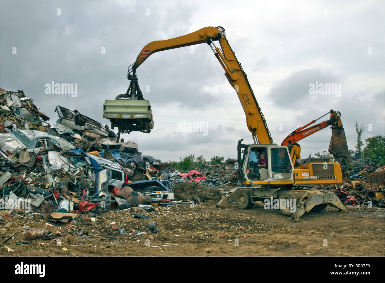 Déchargement de la voiture sur une pile dans un parc à ferraille métallique. Banque D'Images