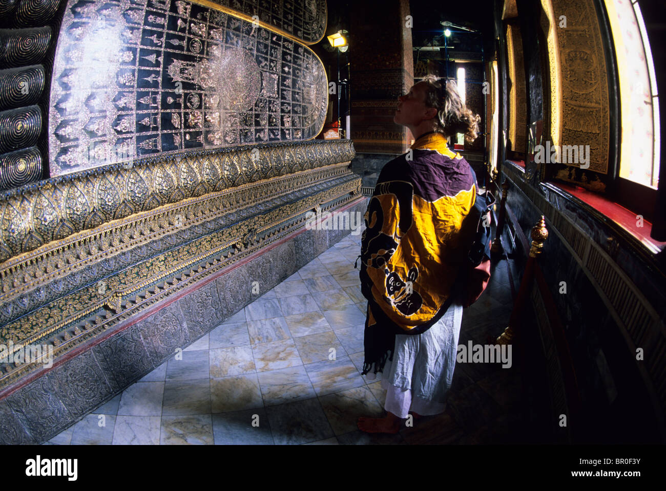 Femme marche par Bouddha couché. Bangkok, Thaïlande. Banque D'Images