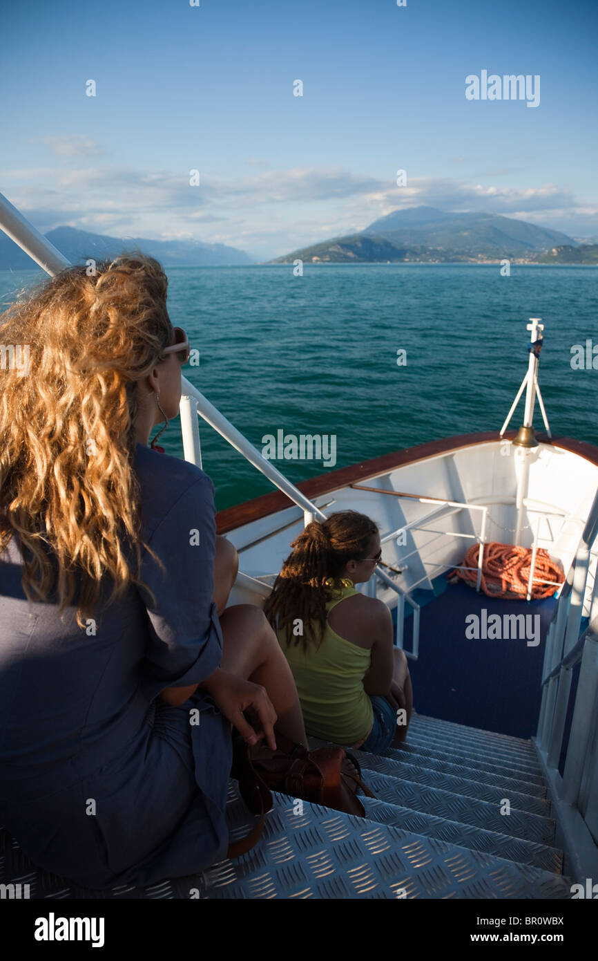 Jeune fille assise de l'escalier ouvert lorsque vous voyagez à bord d'un ferry sur le lac de Garde, Italie Banque D'Images