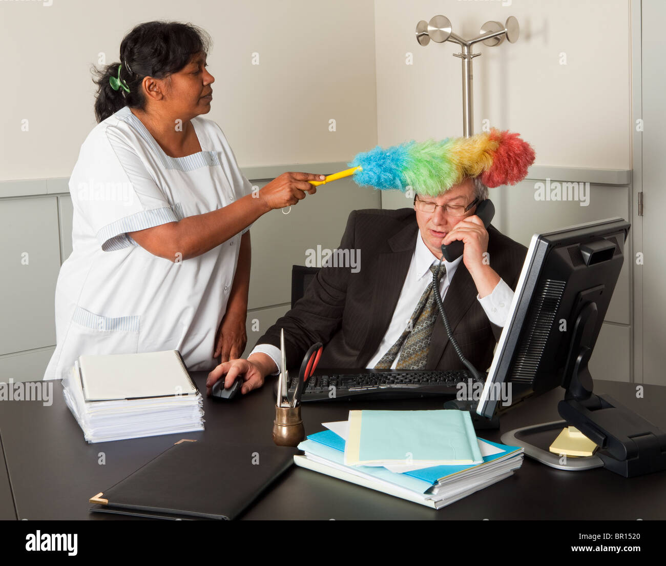 Drôle de femme de ménage de nettoyer le bureau du manager, y compris son  visage Photo Stock - Alamy
