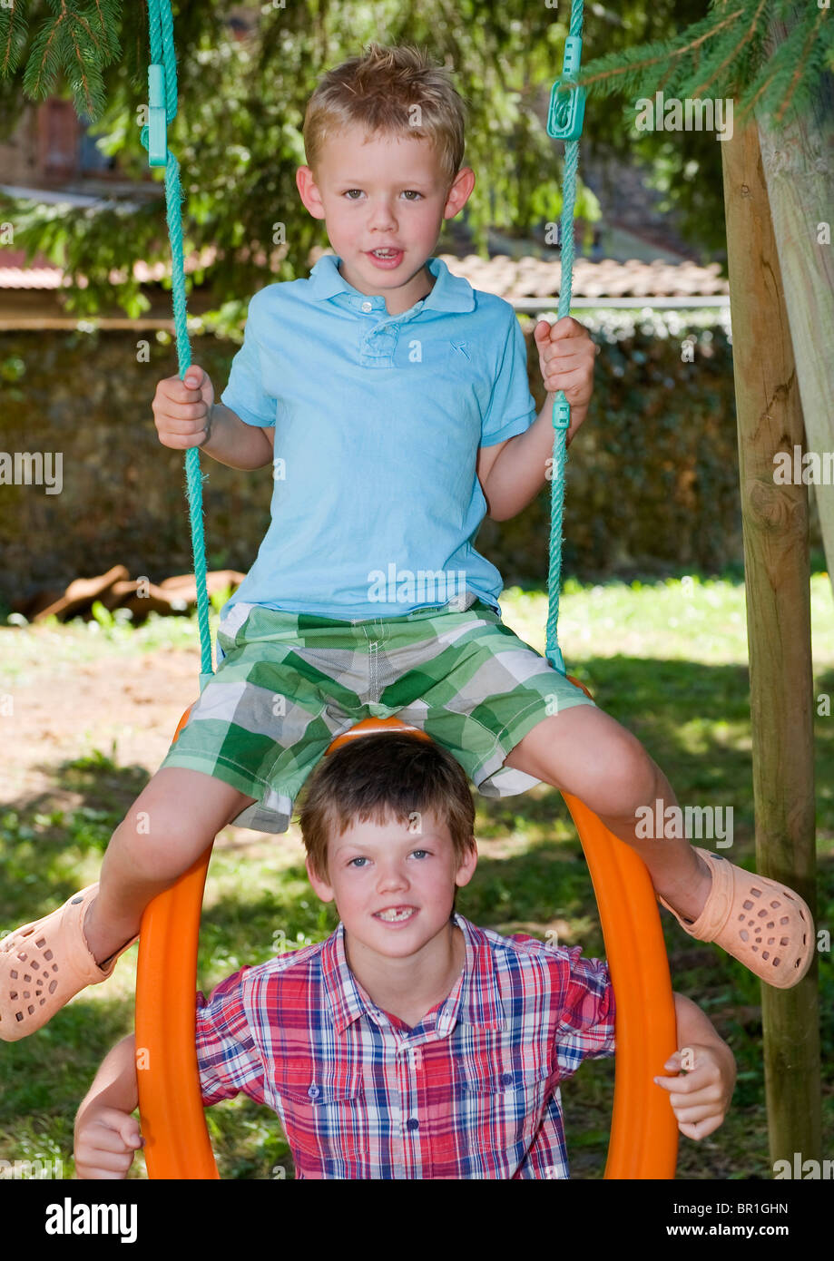 Deux jeunes garçons jouant sur une balançoire Banque D'Images