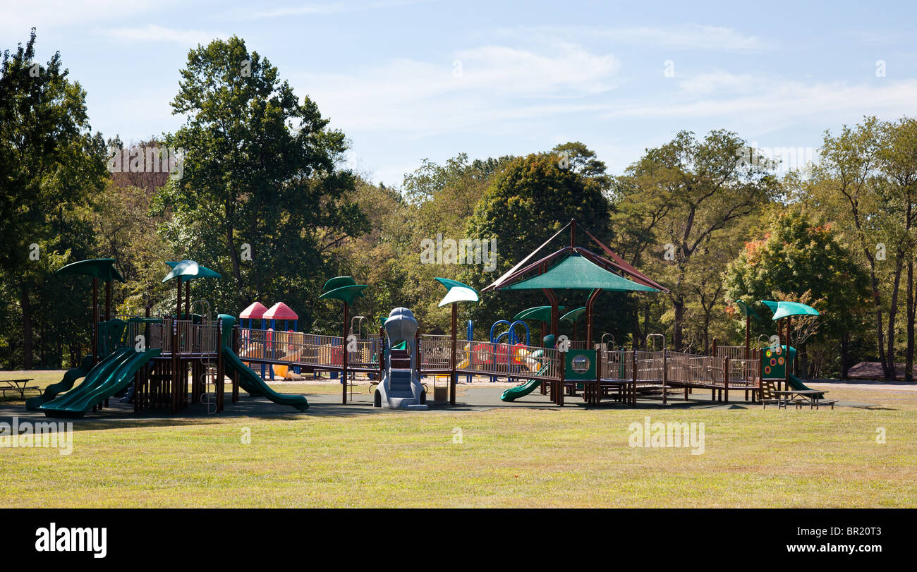 Aire de jeux pour enfants moderne dans parc verdoyant avec des diapositives et des portiques Banque D'Images