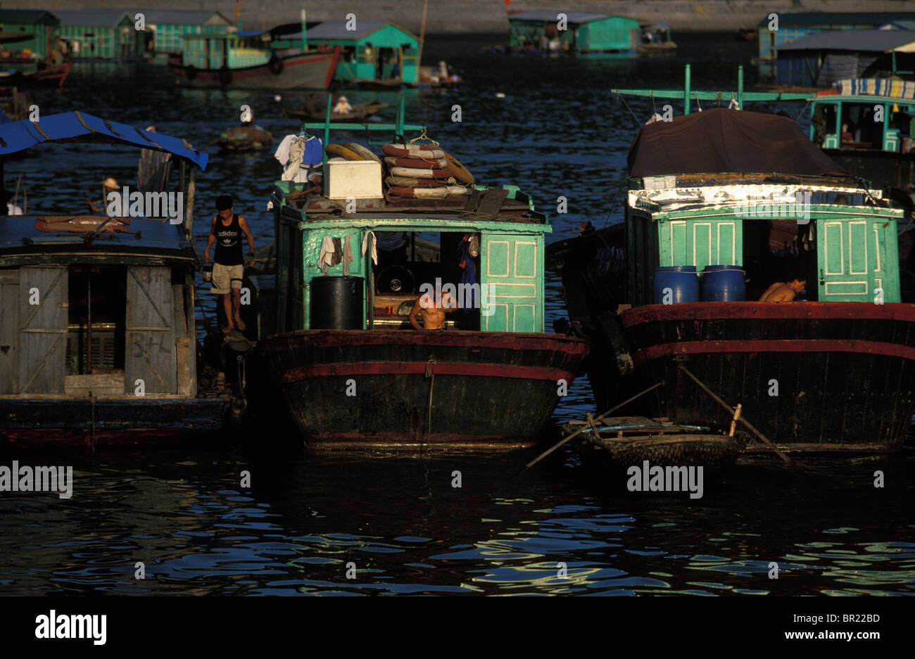 Des gens qui travaillent sur les bateaux d'ordure à Cat Ba, au Vietnam. Banque D'Images