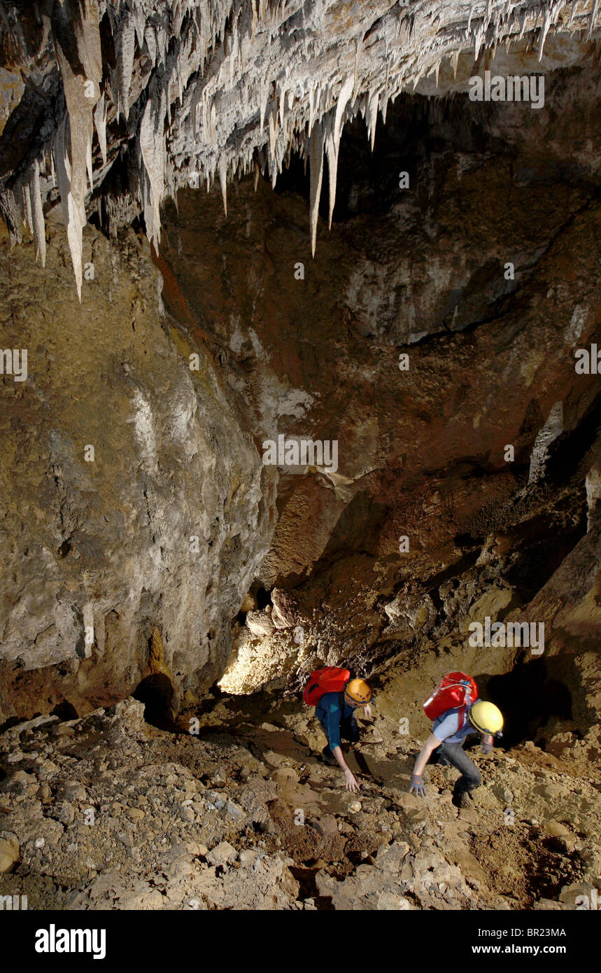 Deux spéléologues plod une pente raide en moellons Whiterock (cave) au plus profond de la jungle malaisienne à Mulu. Banque D'Images