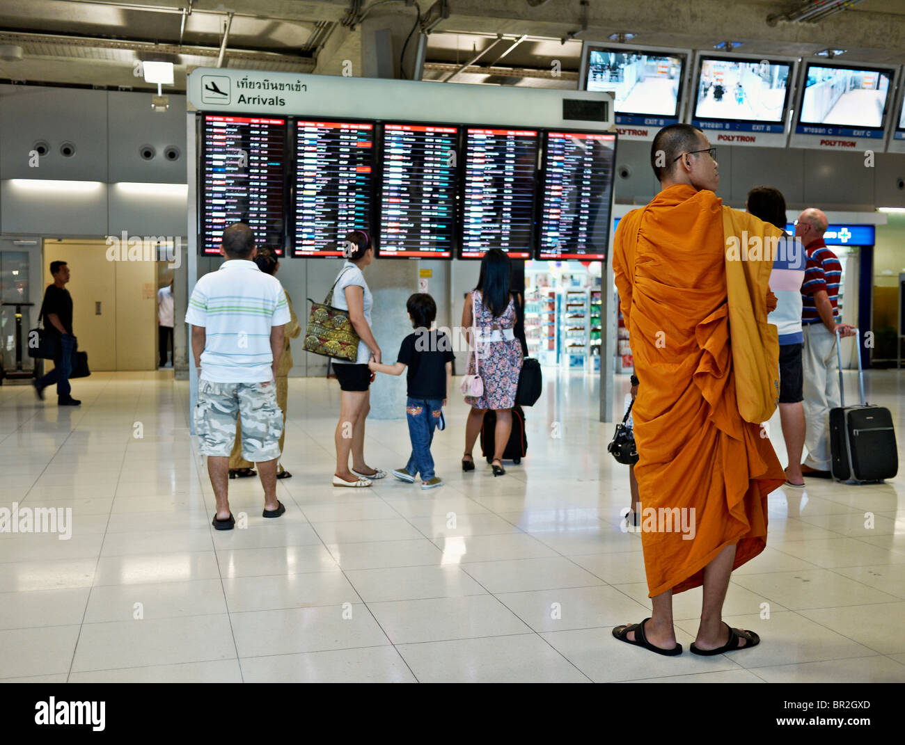 Moine thaïlandais en attente à l'aéroport de Suvarnabhumi zone des arrivées internationales. S. E. Asie Thaïlande Banque D'Images