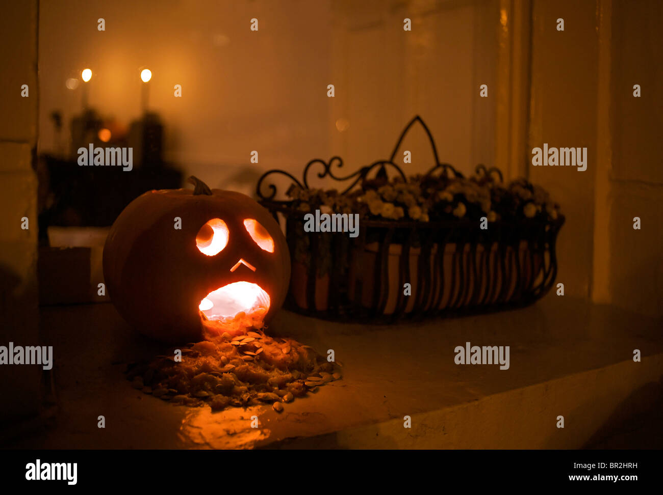 Halloween citrouille vomissant ses entrailles sur un rebord de fenêtre Banque D'Images