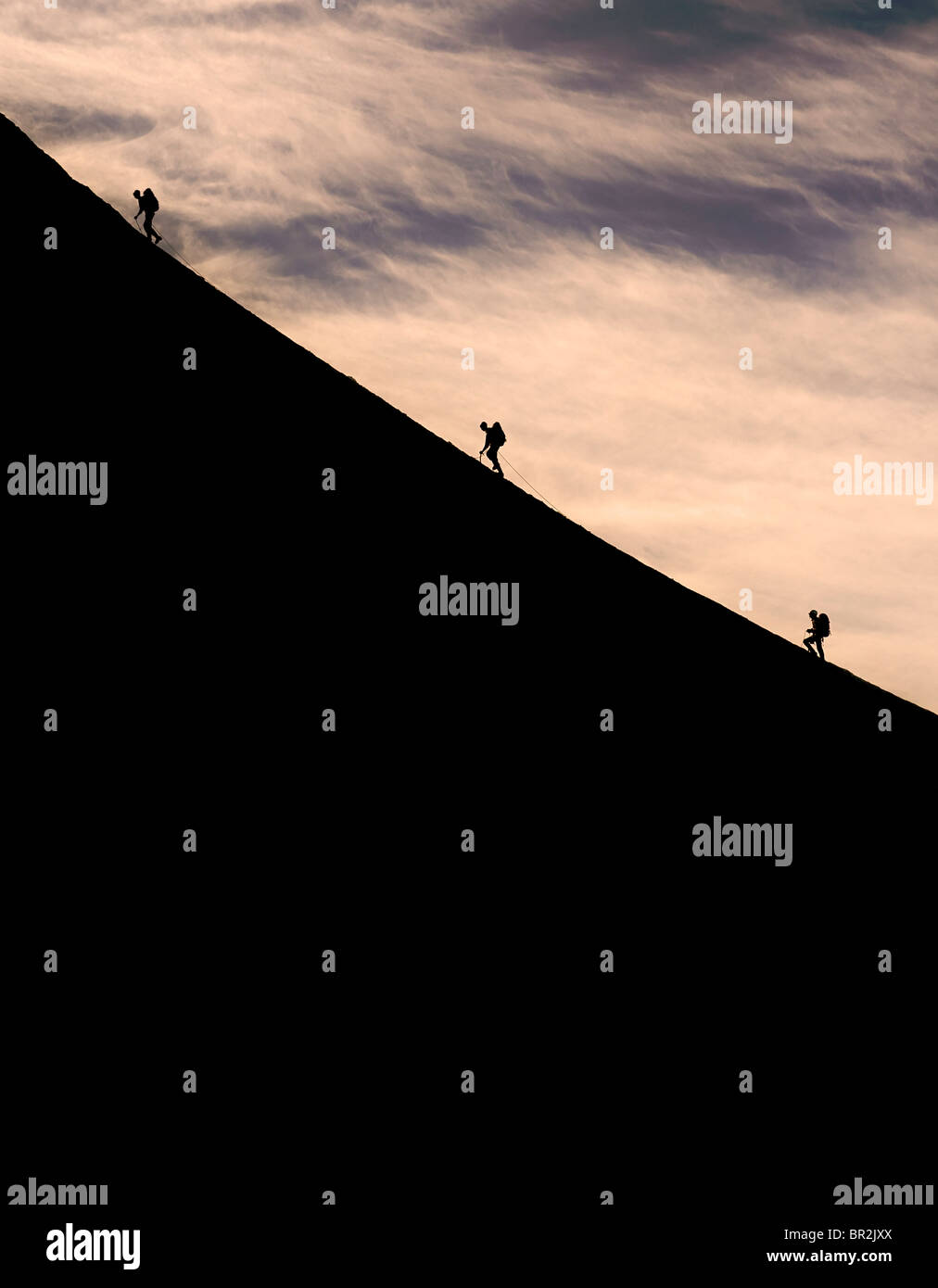 Silhouette d'alpinistes grimper une pente raide sur la crête de l'Alguile du Midi, Chamonix, France Banque D'Images