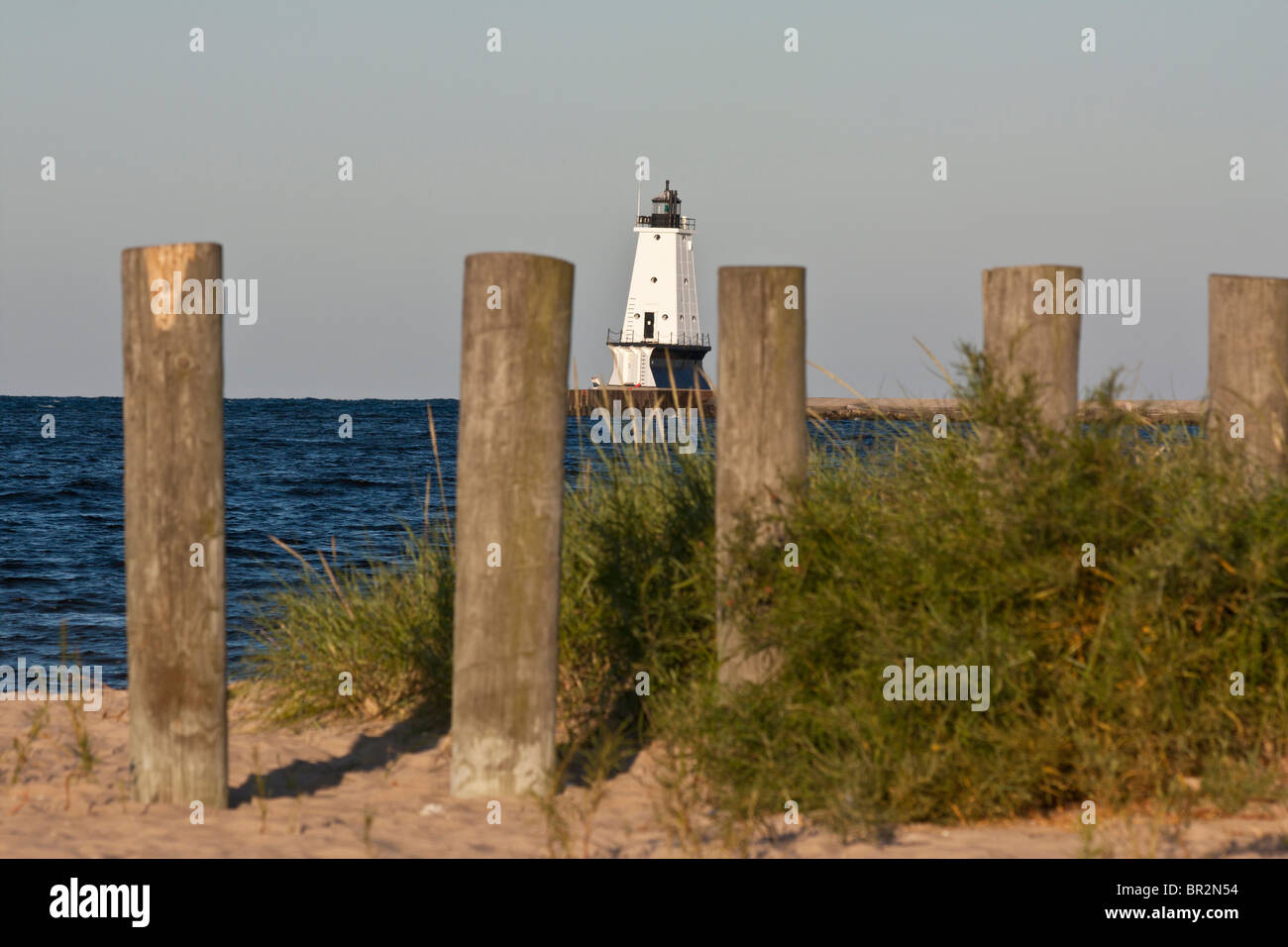 Phare blanc et rangée de piquets en bois dans l'eau de plage de sable Michigan MI lac aux Etats-Unis Grands Lacs personne paysage hors horizon hi-res Banque D'Images