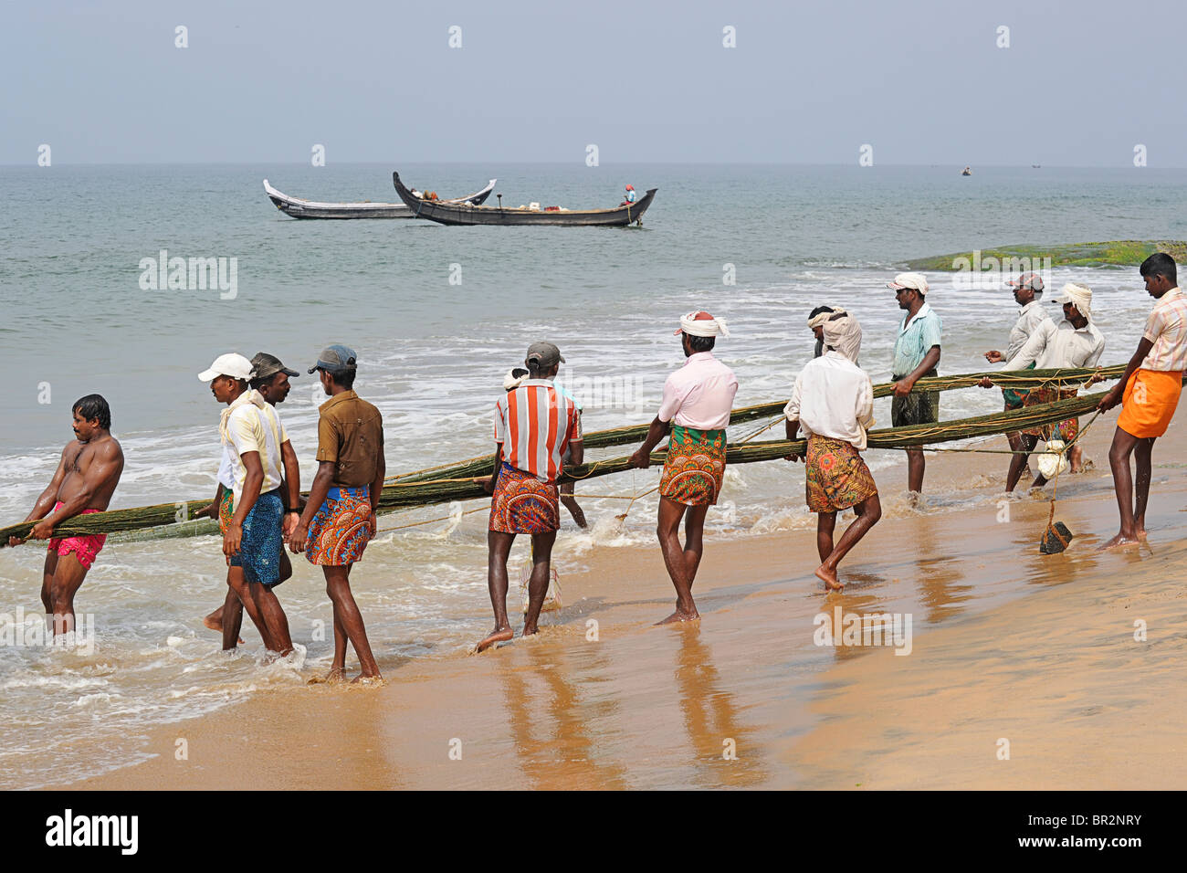 Les pêcheurs de Kovalam en tirant dans un filet de pêche, de l'Inde Banque D'Images