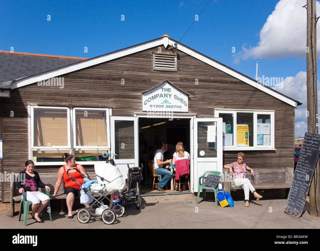 En attente d'un siège à l'abri de l'entreprise boutique et restaurant de fruits de mer, West Mersea, Essex, UK Banque D'Images