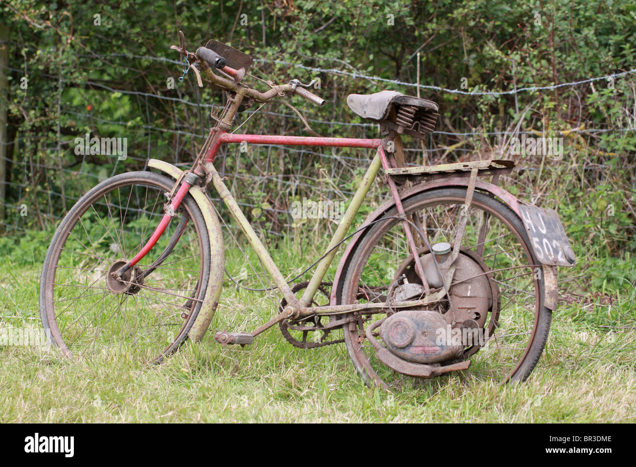 Vieille moto abandonnée dans un champ Banque D'Images
