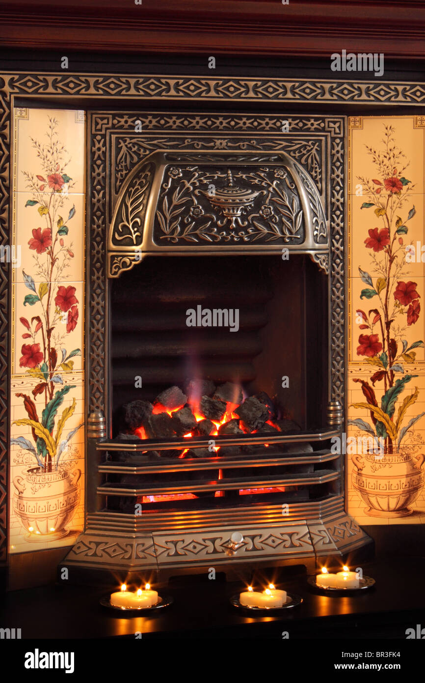 Un feu de gaz avec des charbons, illustré avec des bougies sur le foyer pour faire un accueil chaleureux à sentir un soir hivers Banque D'Images