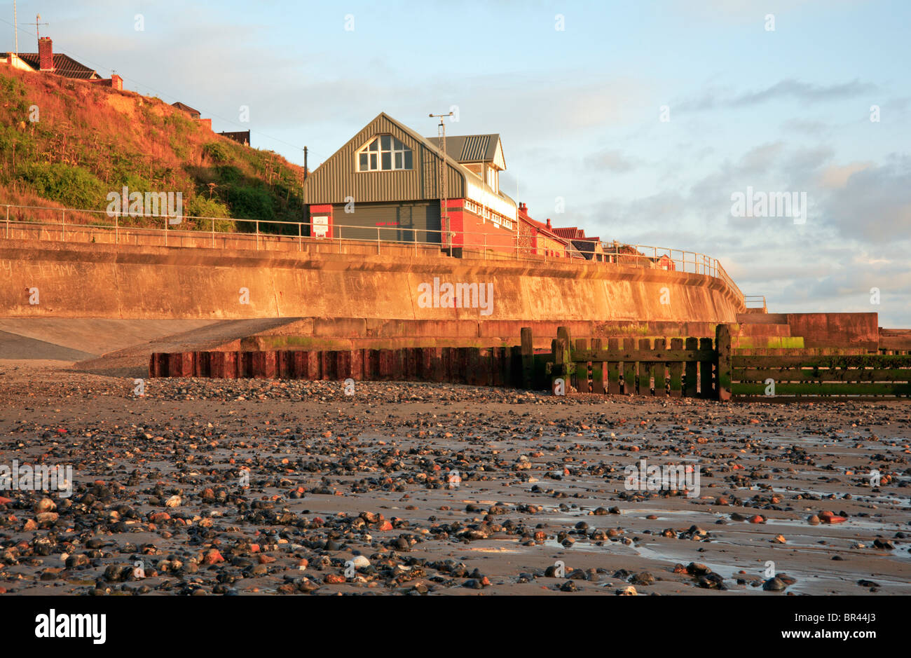 Mur de la mer moderne et d'un hangar à bateaux de sauvetage côtiers à Mundesley sur Mer, Norfolk, Angleterre, Royaume-Uni. Banque D'Images