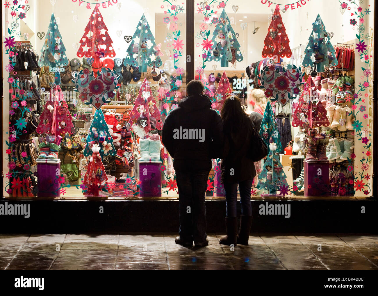 Une vitrine de l'affichage à Noël avec des consommateurs à la recherche de, Cheltenham, UK Banque D'Images