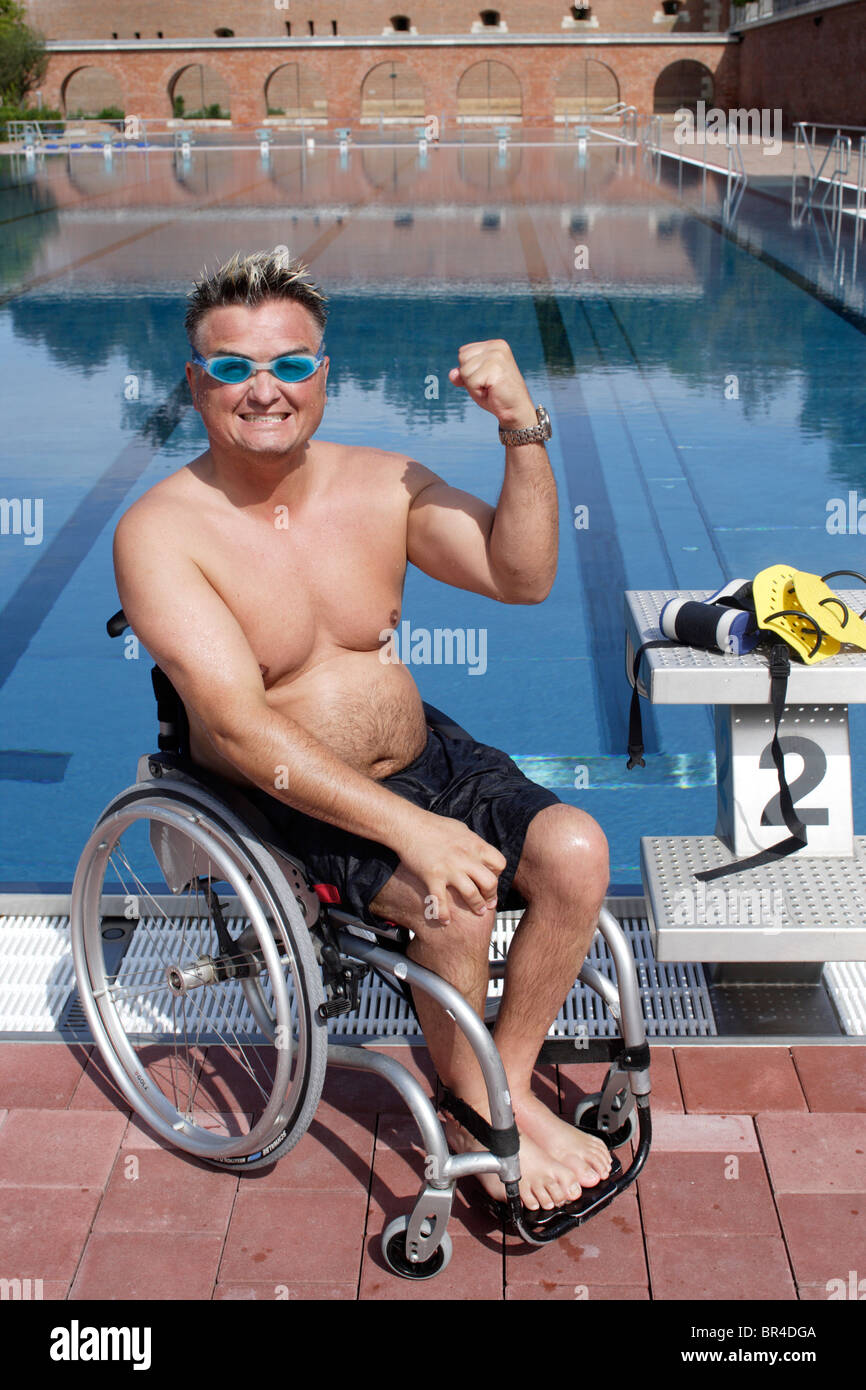 Les jeunes, homme handicapé dans un fauteuil roulant, des exercices de  natation, piscine edge, balled fist Photo Stock - Alamy