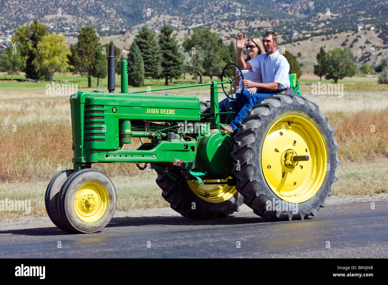 Newlywed couple marié à cheval sur un tracteur dans leur cortège nuptial de l'église à la réception, Salida, Colorado Banque D'Images