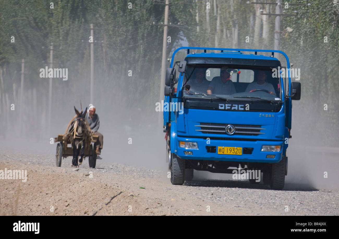 Âne et le partage de la route de camion, Hotan, Xinjiang, Chine Banque D'Images