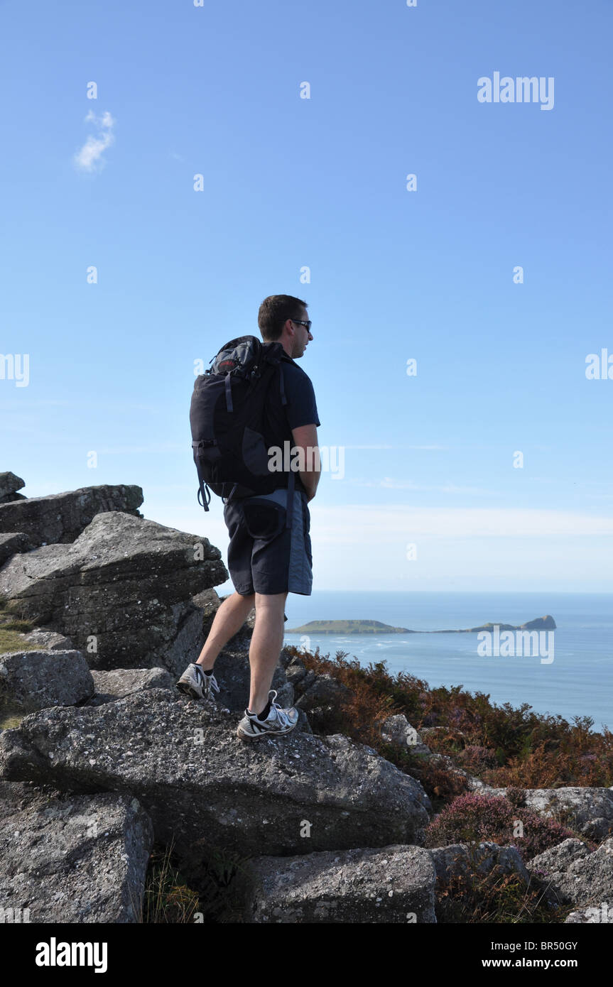 Jeune homme regardant la mer sur la promenade côtière au Pays de Galles Banque D'Images